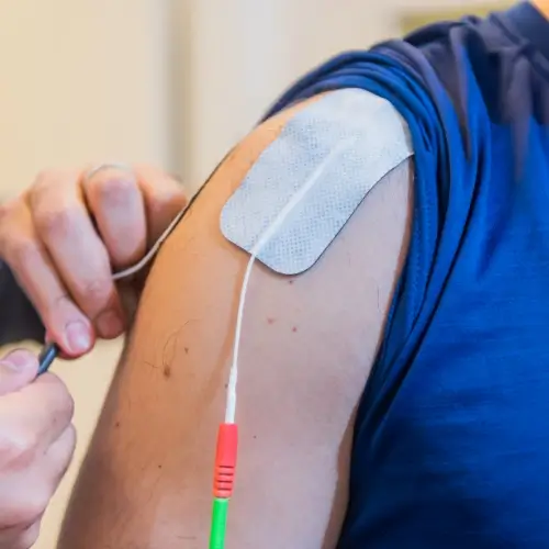 Electrotherapy device applied to shoulder for pain relief