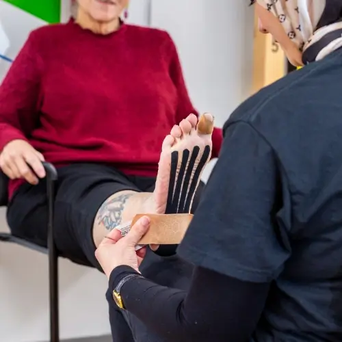Therapist applying kinesiology tape to support muscles